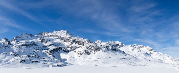 Fototapeta na wymiar Spectacular landscape of the Bernina Pass in Switzerland on a winter day with lots of sunshine. All the mountains are covered with a lot of snow.