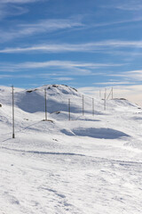 Spectacular landscape of the Bernina Pass in Switzerland on a winter day with lots of sunshine. All the mountains are covered with a lot of snow.