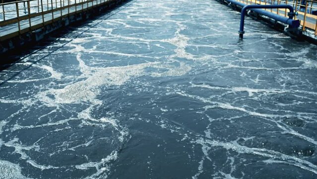 Process of purification effluent water flowing in outdoor channels at wastewater treatment plant facility.