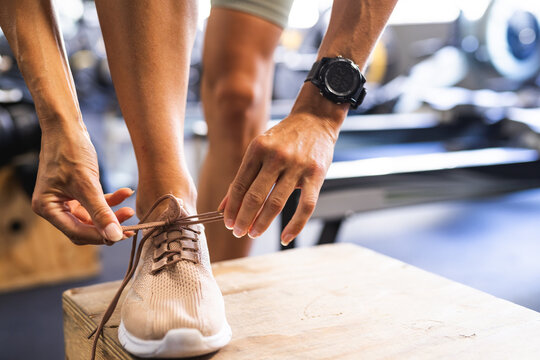 Fit person tying shoe laces before a workout at the gym