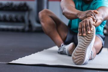Fit African American man stretching at the gym