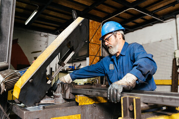 Fototapeta premium Senior bearded man working in factory workshop