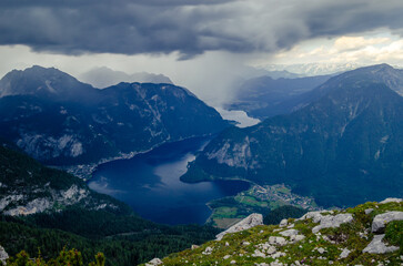 Fototapeta na wymiar A beautiful view of mountains, clouds and rain during the summer in Hallstatt, Austria.