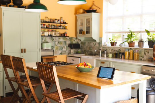 A modern kitchen interior features a tablet on the table