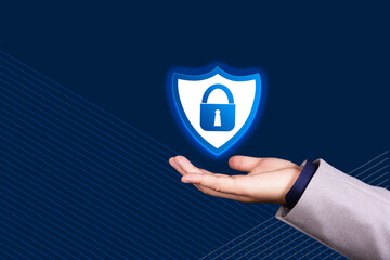 Businessman hand holds shield icon and sign of padlock on blue background. GDPR, General Data...