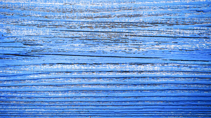 An old wooden background, painted bright blue. Wooden surface with cracks.