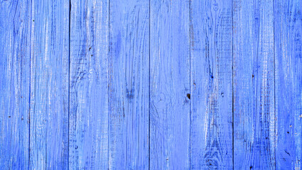 Fototapeta na wymiar An old wooden background, painted bright blue. Wooden surface with cracks.
