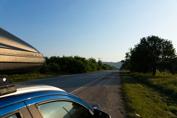 Family travel car with roof rack on a mountain road.