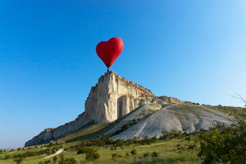 Hot air balloon, Red balloon in the shape of a flying heart against the background of the White...