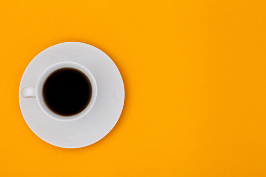 Top view image of coffee cup on orange paper background. Copy space for input the text. Flat lay. 