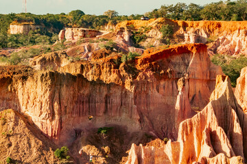 Scenic view of tourists dwarfed by rock formations at Marafa Depression - Hell's Kitchen at sunset...