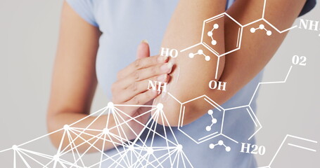 Image of chemical structures over biracial woman putting cream on her arm - Powered by Adobe
