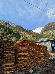A stack of logs and branches neatly arranged beside the building, ready to be used for warmth or...