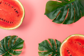 Watermelon with palm tree leaf on pink background. Creative minimal summer concept.
