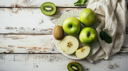 White plate topped with green apples and kiwi. Perfect for healthy eating and nutrition concepts