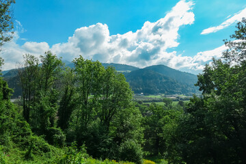 Scenic view from castle Rabenstein in Frohnleiten in Styria, Austria. Landscape of green alpine meadow, bushes and high grass in the valley of Grazer Bergland in Styria, Austria. Cloudscape