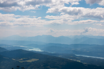 Panoramic view of Lake Ossiach surrounded by majestic mountain peaks of Karawanks and Julian Alps. Wanderlust on Gerlitzen Alpe,  Carinthia, Austria. Idyllic hiking trail in Austrian Alps in summer