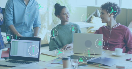 Image of ecology icons over diverse business people in office