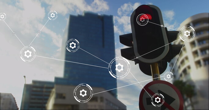 Image of network of conncetions with icons over traffic lights and cityscape