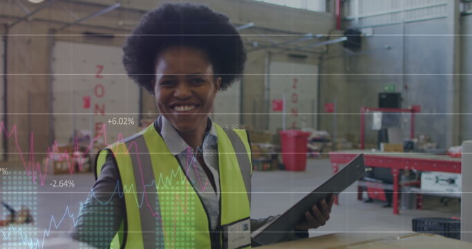 Image of statistics and data processing over african american woman working in warehouse - Powered by Adobe
