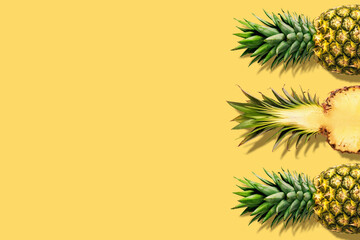 Fresh pineapples on yellow background. Creative suumer concept.