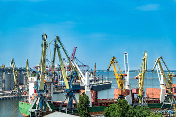 Cranes and cargo ships in the port of Odessa Ukraine - obrazy, fototapety, plakaty