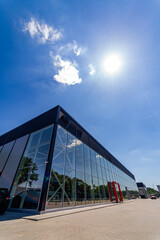 Modern building of the airport terminal with blue sky and the sun