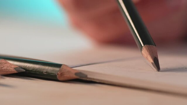 Hand Draws Lines with a Pencil, art of sketching. Close-up, shallow dof.