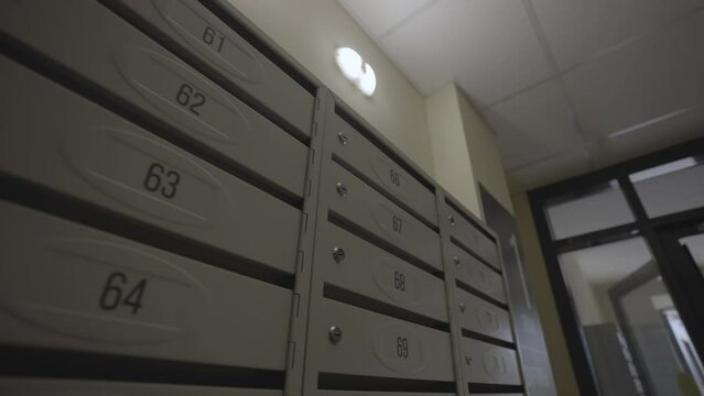 Modern mailboxes with numbers at entrance of residential building. Floor signboard assists guests in locating desired floor and apartment