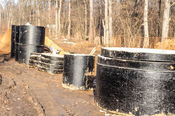 Fototapeta premium Pipeline laying in the ground. Concrete wells