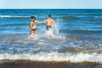 Middle aged couple exercising together on the beach this summer