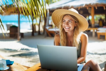 Cheerful young woman working on a laptop on vacation. Copy space.