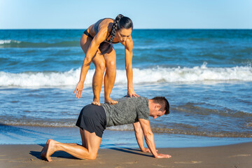 Middle aged couple exercising together on the beach this summer