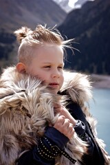 Portrait of a young boy in the viking cosplay costume with Mountains view