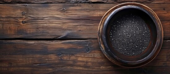 Fototapeta premium Empty wooden table with black sesame bowl, room for text.