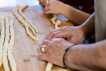 grandmother and granddaughter prepare homemade pasta called 
