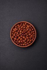 Delicious hazelnut whole, raw, without shell, on a dark concrete background