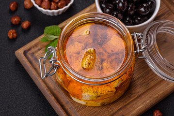 Delicious soft white feta cheese with salt, spices and herbs on a dark concrete background