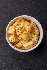Delicious soft white feta cheese with salt, spices and herbs on a dark concrete background
