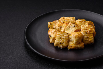 Delicious soft white feta cheese with salt, spices and herbs on a dark concrete background