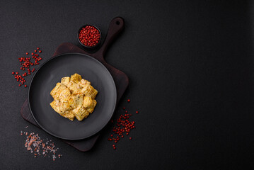 Delicious soft white feta cheese with salt, spices and herbs on a dark concrete background