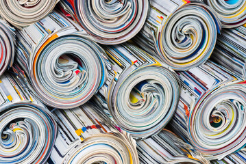 Stack of old rolled up colored newspapers
