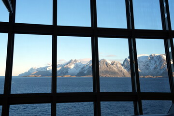 Blick durch eingerahmte Glasfenster auf einem Kreuzfahrtschiff auf die Lofoten am Moskenstraumen,...