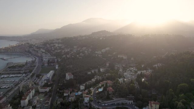 Menton France in the Cote D'azur Mediterranean south coast during dusk sunset with Marina, Aerial pan left shot