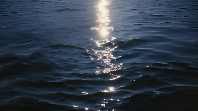 The suns reflection on the water creates a striking contrast against the deep blue of the sky in the early morning or late evening.