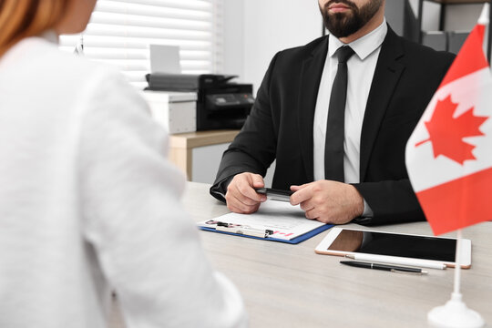 Immigration to Canada. Woman having interview with embassy worker in office, closeup