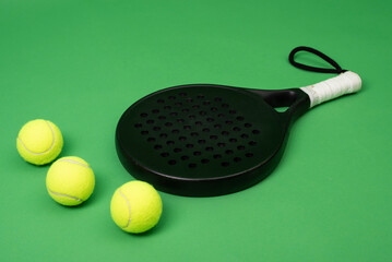 Isolated on green paddle tennis racket and balls, sports objects