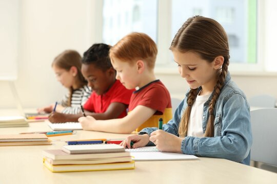 Cute children studying in classroom at school