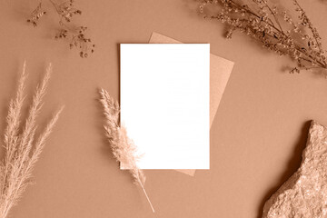 Blank greeting card, invitation mockup. Dry grass, pampas plant on beige table background. Flat...