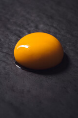 Egg yolk on black textured background